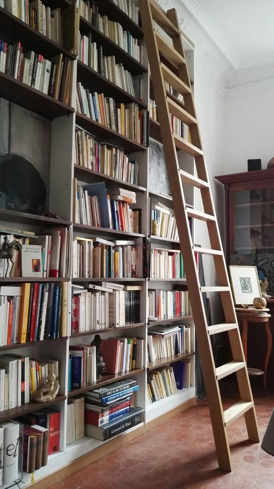 Bibliothèque en bois sur toute la hauteur, avec échelle intégrée