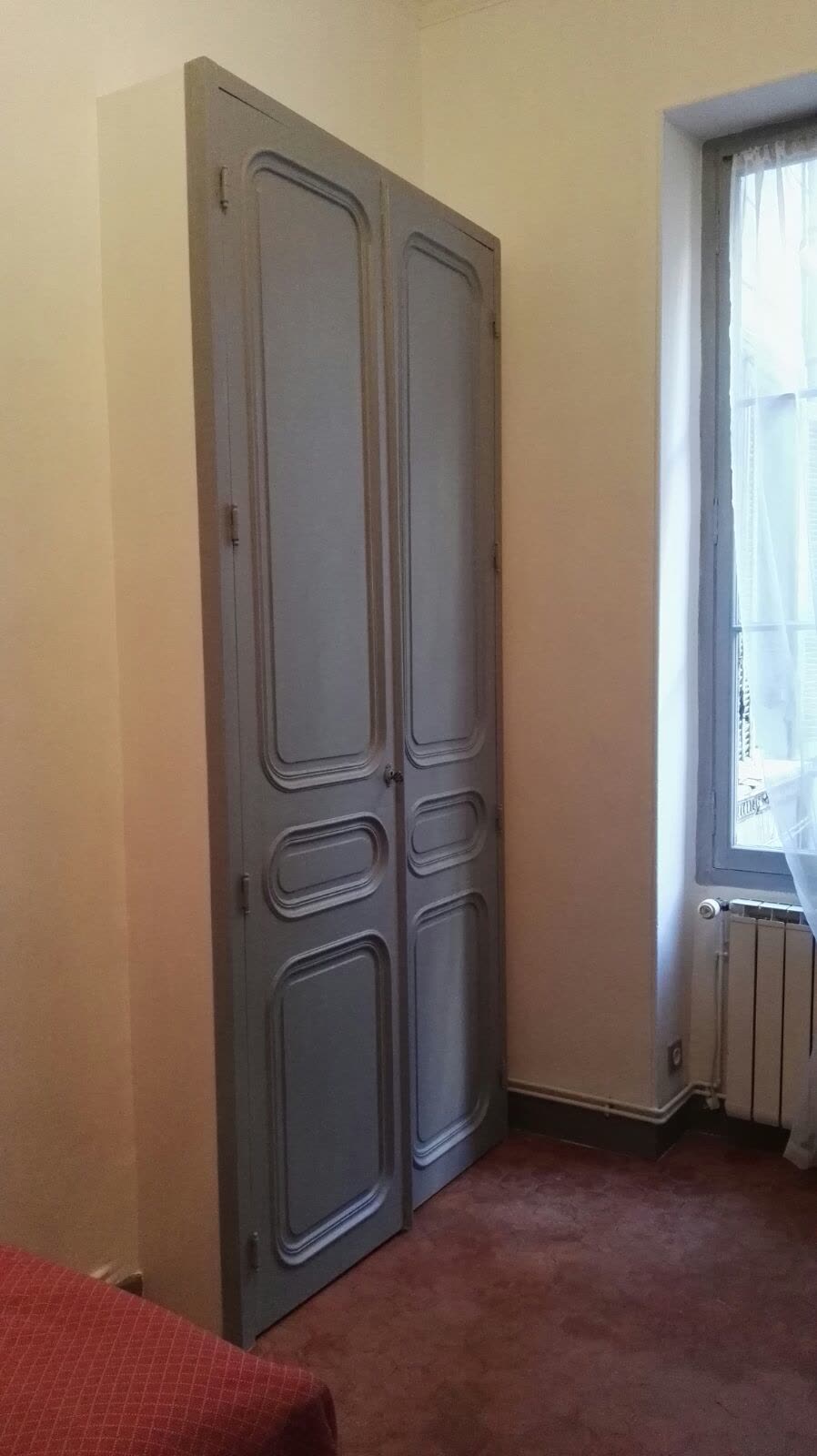 Meuble en bois à deux portes dans une pièce lumineuse