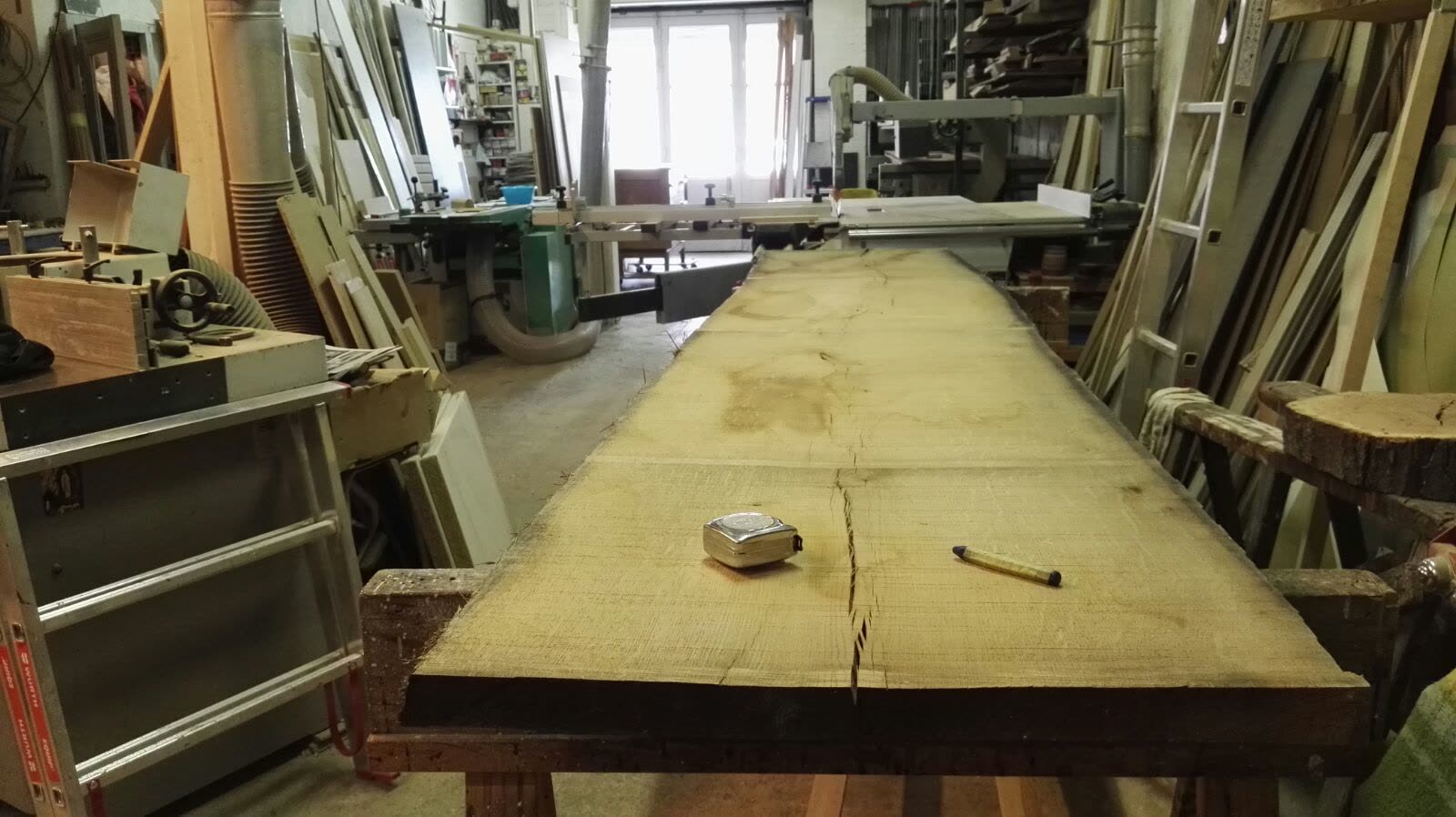 Grand plateau de bois brut posé dans l’atelier de menuiserie